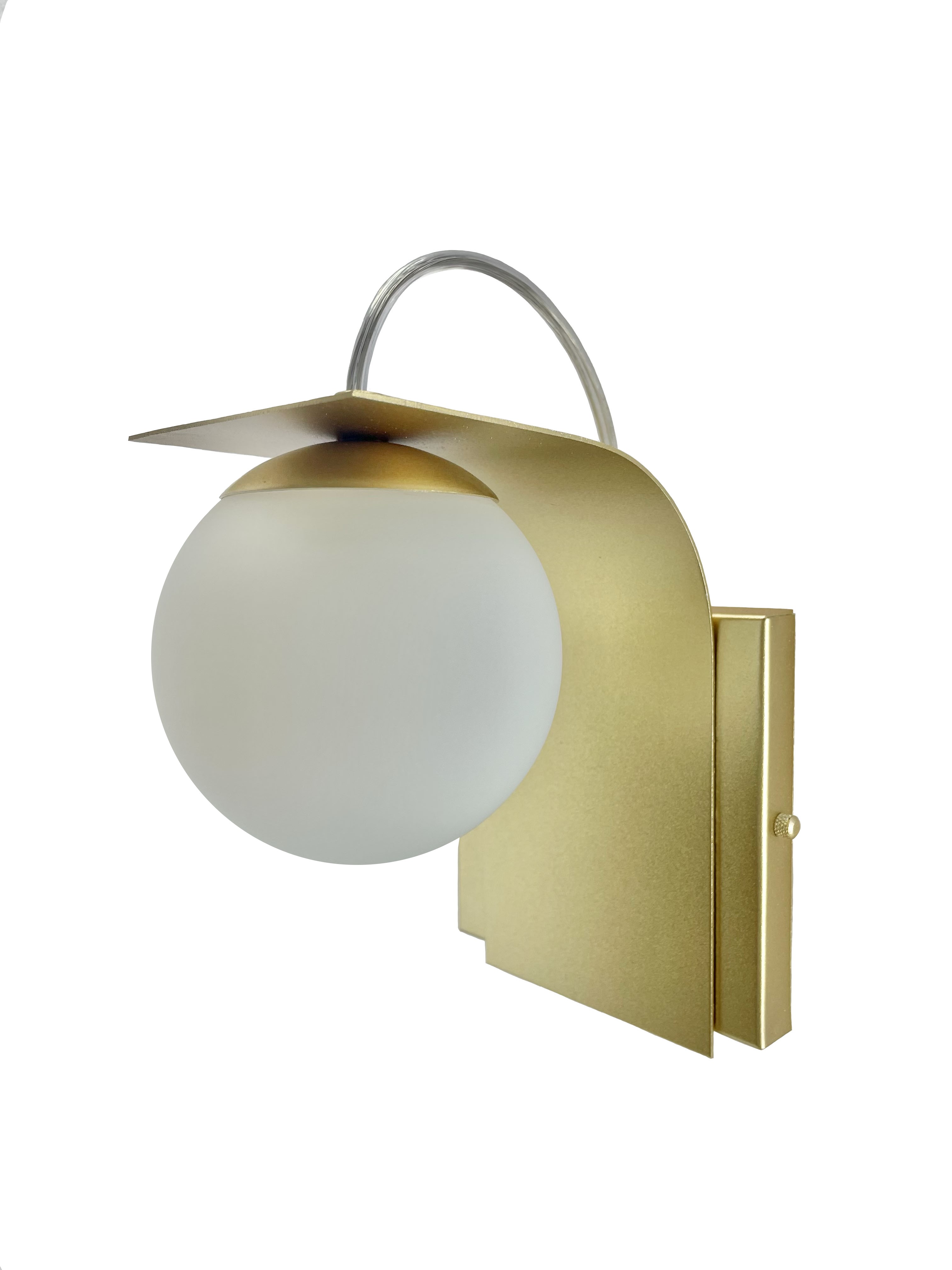 Arandela moderna Clama com design elegante e chapa de alumínio dourada, ideal para cabeceira de cama e lavabos. Lustres Gênesis loja online de Lustres e Iluminação Decorativa